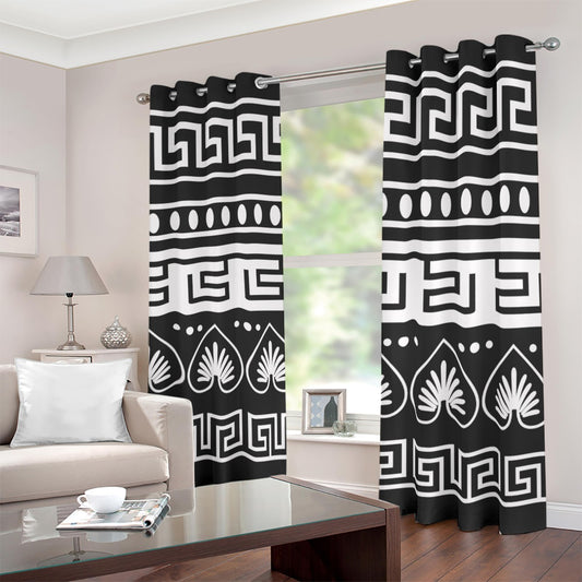 Black and white patterned grommet curtains hanging on a silver rod in a living room setting.
