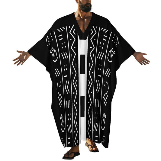 A man modeling a black kaftan robe with white geometric tribal patterns, shown against a plain white background.