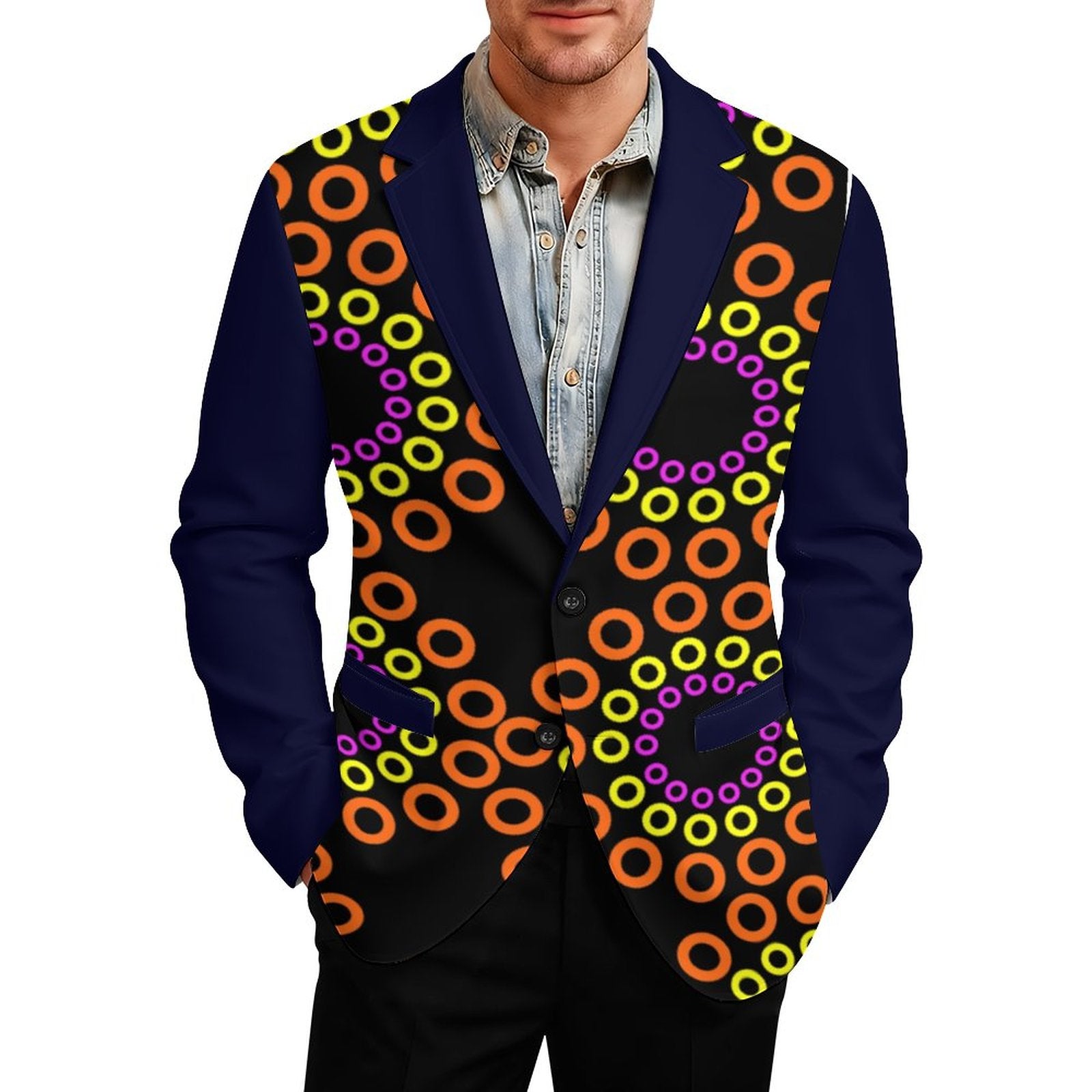 A man wearing a custom-designed blazer with a navy blue base, featuring a vibrant black front panel decorated with a repeating pattern of orange, yellow, and purple concentric rings, paired with a light blue denim shirt.
