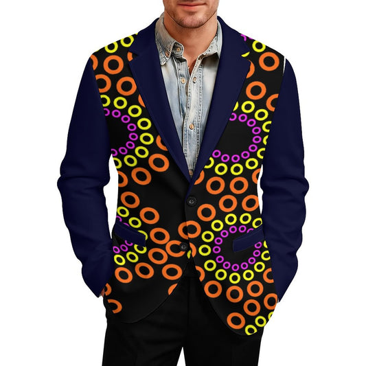 A man wearing a custom-designed blazer with a navy blue base, featuring a vibrant black front panel decorated with a repeating pattern of orange, yellow, and purple concentric rings, paired with a light blue denim shirt.