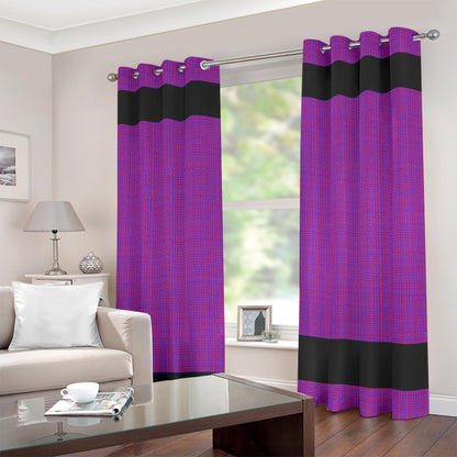 A pair of purple and black grommet curtain panels hanging on a silver rod in a living room setting with a sofa, lamp, and coffee table visible.