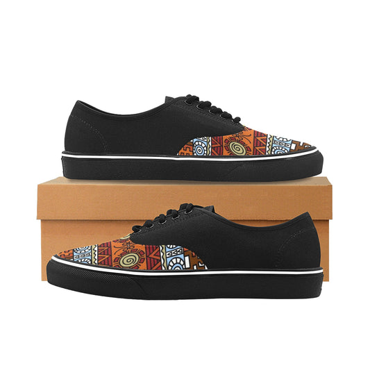 A pair of black low-top canvas sneakers with a colorful geometric and tribal-inspired pattern on the toe box, displayed on a brown shoebox against a white background.