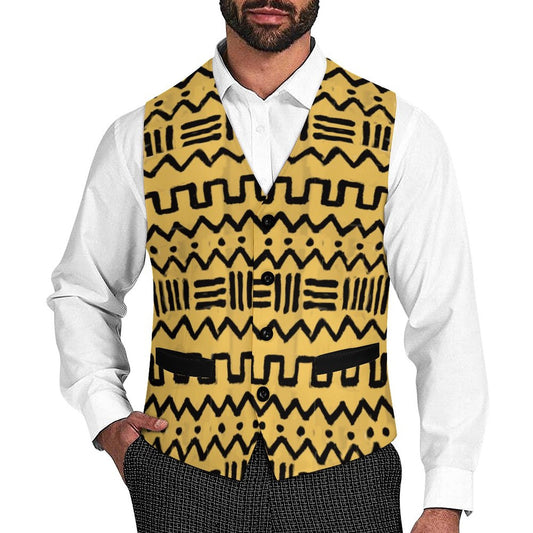 A man wearing a yellow vest with a black geometric tribal pattern over a white collared shirt and dark patterned trousers, shown from the chin down on a plain white background.