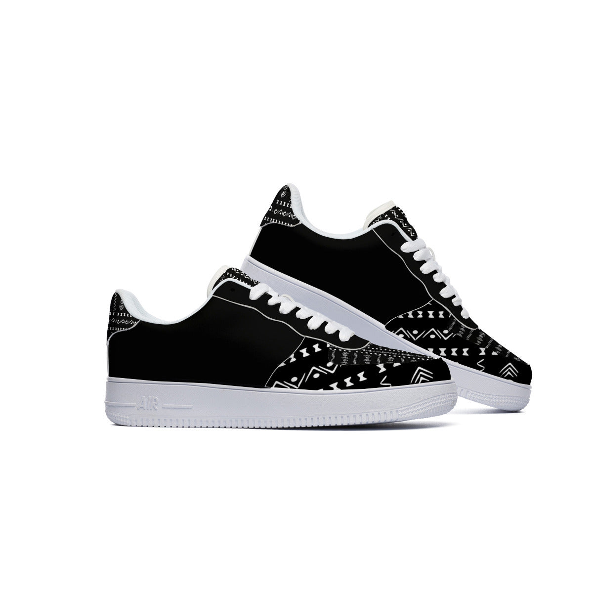 A pair of black low-top sneakers with white geometric tribal-style patterns on the toe box and heel, featuring white laces and white midsoles, shown against a plain white background.