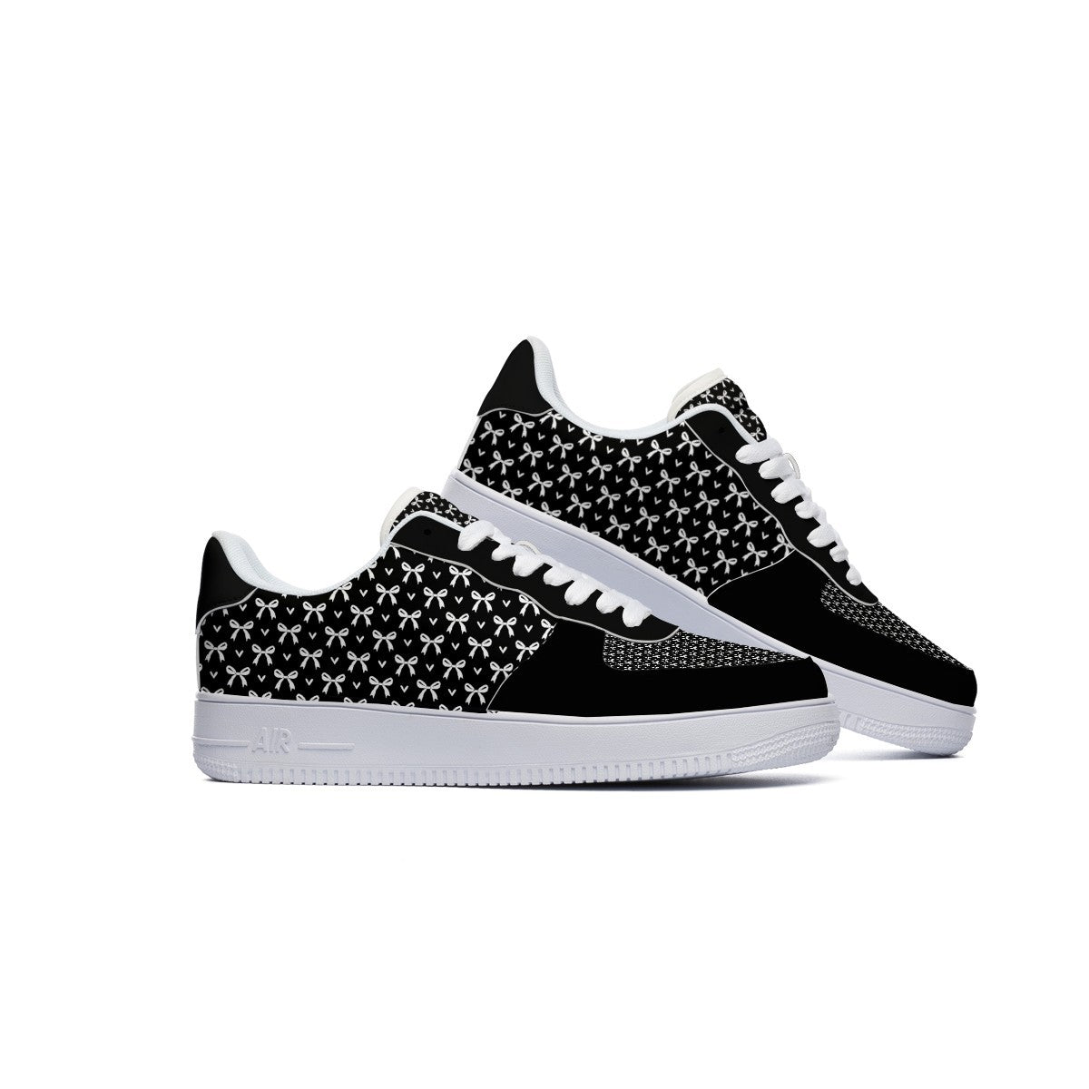 A pair of low-top sneakers in black and white, featuring a black and white geometric pattern on the side panels, white laces, and white soles, set against a plain white background.