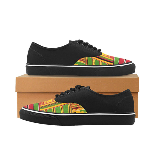 A pair of black low-top canvas sneakers with a colorful African Kente pattern on the toe box, displayed on a brown shoebox against a white background.