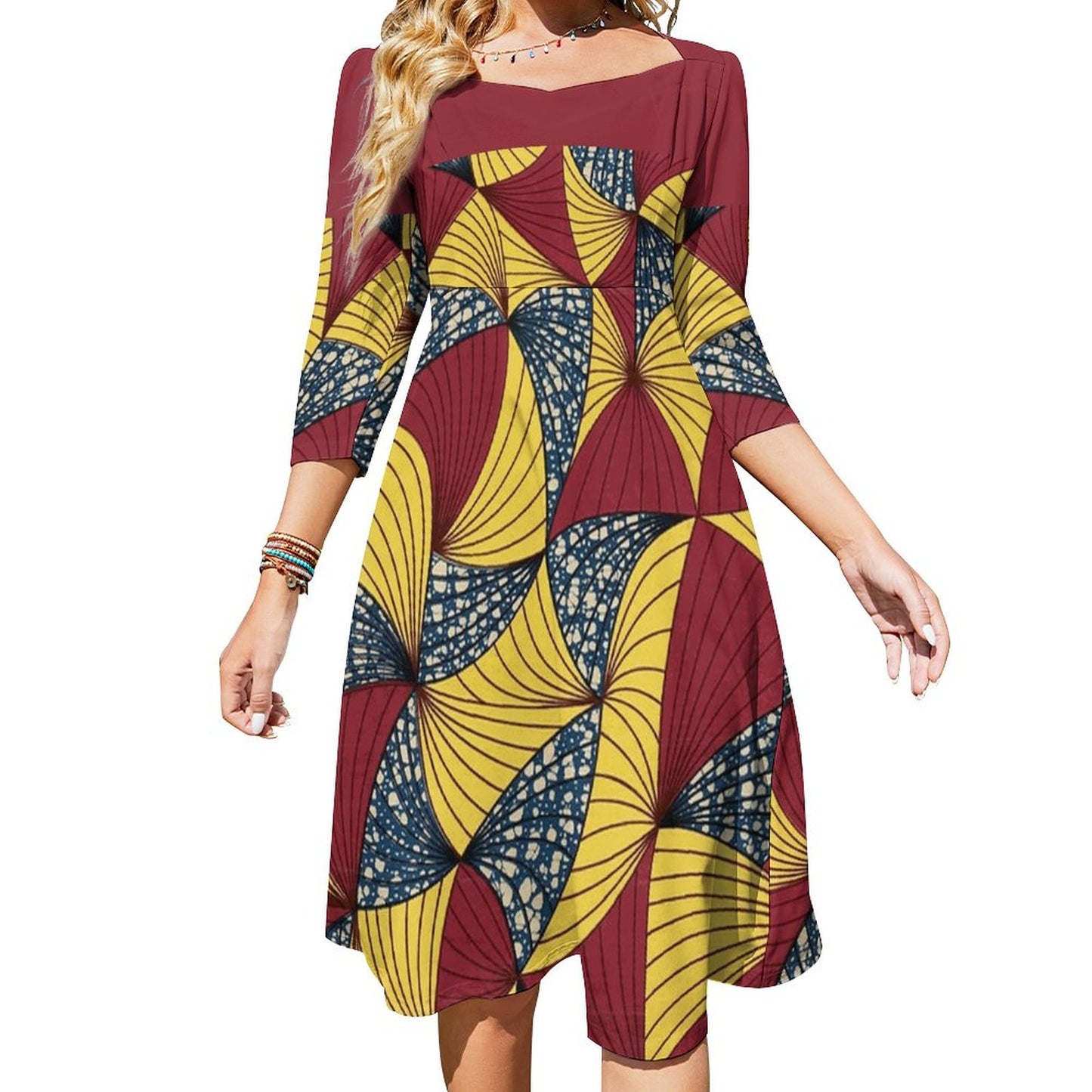 A woman wearing a three-quarter sleeve A-line dress with a bold geometric African wax print in maroon, mustard yellow, and navy blue, shown against a plain white background.